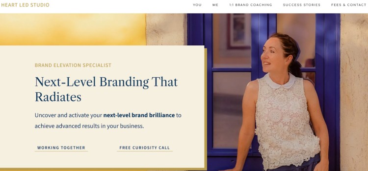 Brand elevation specialist standing confidently beside a blue-framed window, promoting next-level branding services to help clients reach new levels in their business.