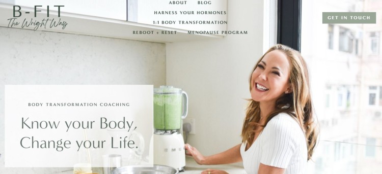 Beth Wright, health and wellness coach, smiling in kitchen while preparing a smoothie