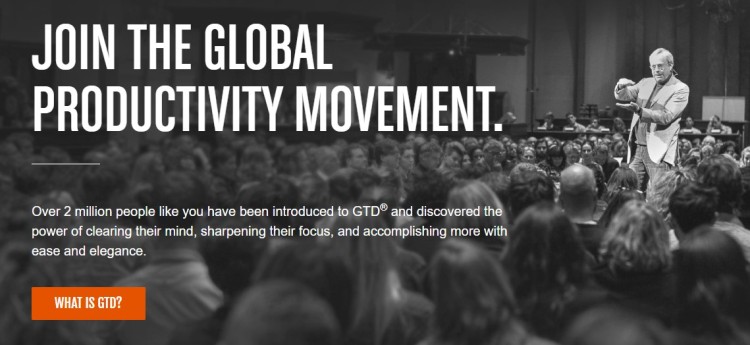 Speaker addressing a large audience at a productivity event promoting effective productivity through focus, clarity, and proven productivity systems.